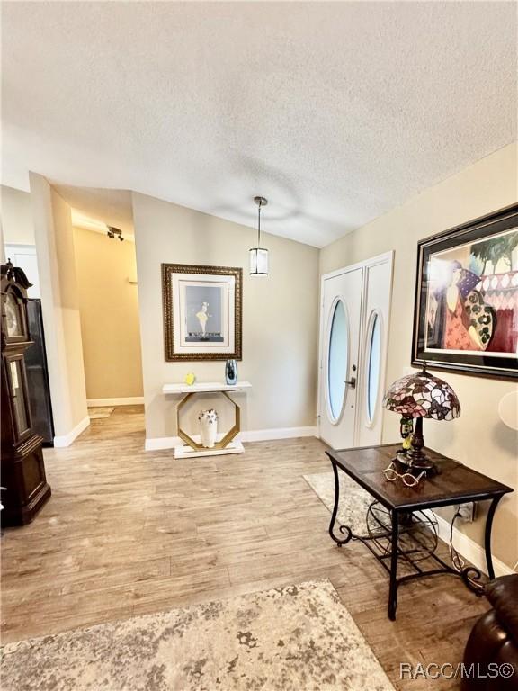 foyer entrance featuring a textured ceiling and light hardwood / wood-style floors