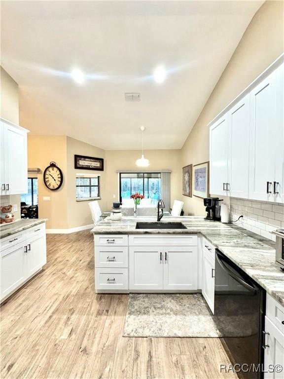 kitchen with white cabinets, dishwasher, lofted ceiling, sink, and kitchen peninsula