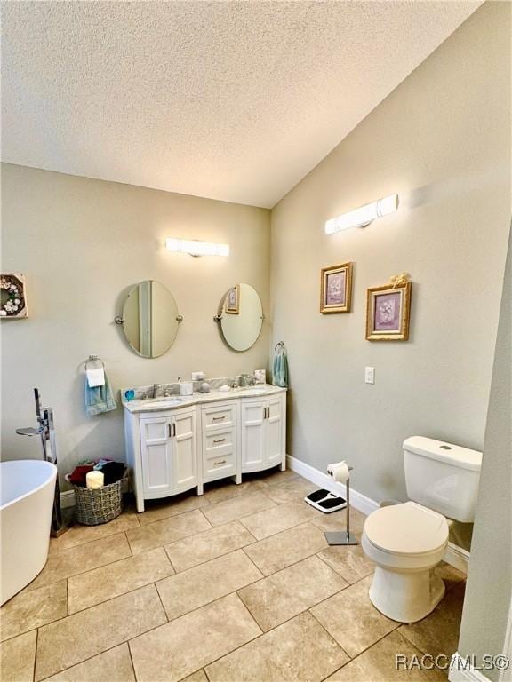 bathroom featuring toilet, vanity, tile patterned flooring, a bath, and a textured ceiling