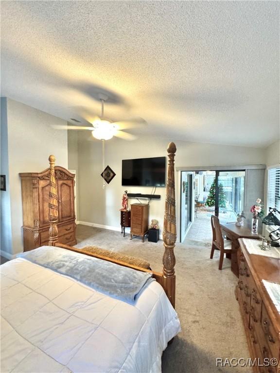 bedroom with light carpet, ceiling fan, and a textured ceiling