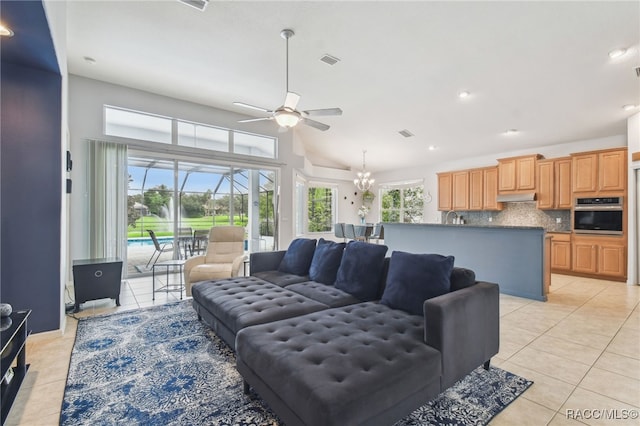 living room with light tile patterned floors, ceiling fan with notable chandelier, and a healthy amount of sunlight