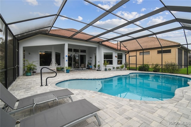 view of pool with a lanai, ceiling fan, and a patio