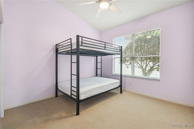 unfurnished bedroom with ceiling fan, light carpet, and vaulted ceiling