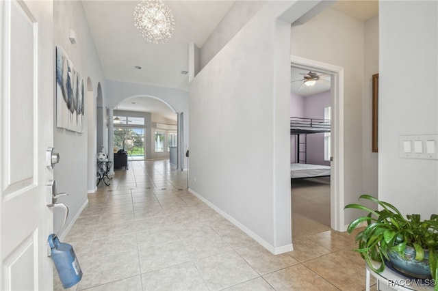 interior space with ceiling fan with notable chandelier