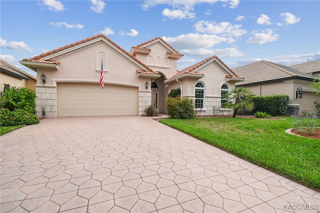 mediterranean / spanish house featuring a front yard, a garage, and central AC unit