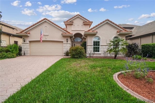 1049 W Lake Valley Ct, Hernando, FL 34442 - mediterranean / spanish-style home with an attached garage, a front yard, decorative driveway, stucco siding, and a tiled roof
