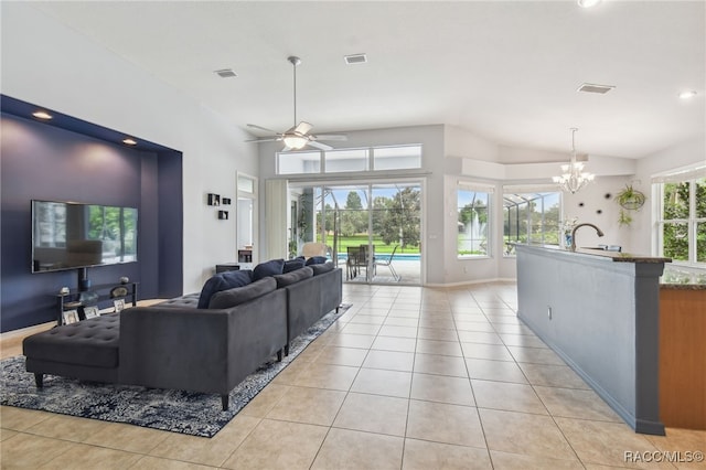 living room with sink, light tile patterned flooring, and ceiling fan with notable chandelier