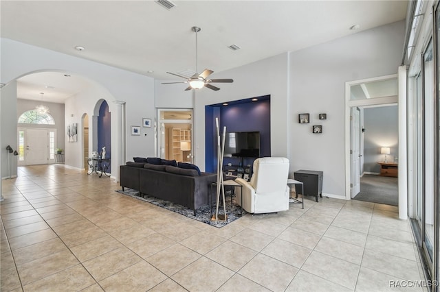 1049 W Lake Valley Ct, Hernando, FL 34442 - living area featuring arched walkways, light tile patterned floors, a ceiling fan, a towering ceiling, and baseboards