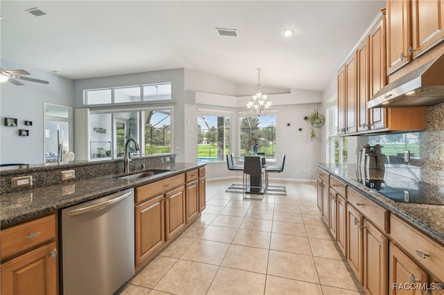 kitchen featuring dark stone countertops, dishwasher, pendant lighting, and sink