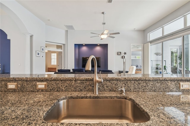 1049 W Lake Valley Ct, Hernando, FL 34442 - kitchen featuring a sink, ceiling fan, arched walkways, dark stone counters, and plenty of natural light