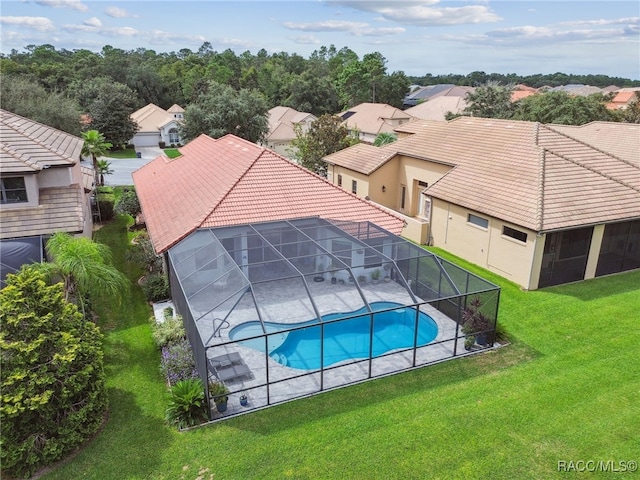 view of swimming pool with a lanai and a lawn