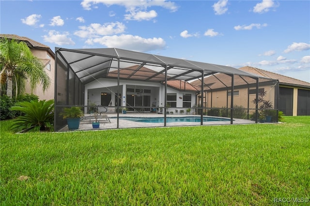 back of house with a lawn and glass enclosure