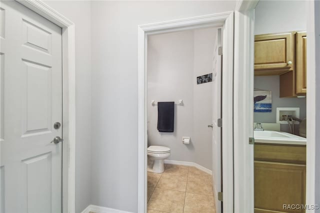 bathroom with tile patterned flooring, vanity, and toilet