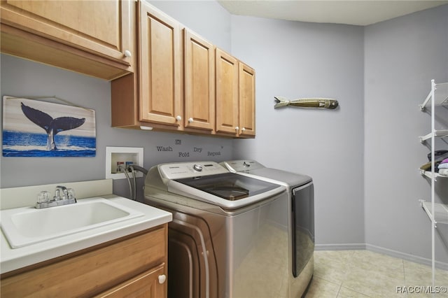 laundry room featuring cabinets, light tile patterned floors, separate washer and dryer, and sink