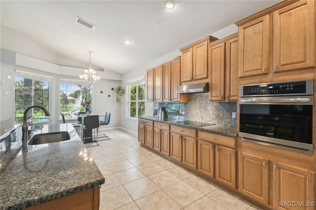 kitchen with vaulted ceiling, sink, dark stone countertops, a chandelier, and oven