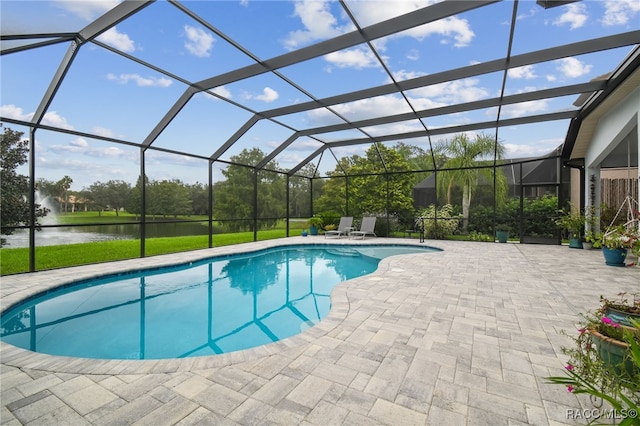 view of pool featuring glass enclosure, a water view, and a patio