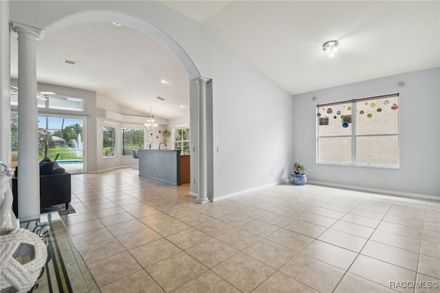 unfurnished room featuring ceiling fan with notable chandelier, ornate columns, light tile patterned floors, and vaulted ceiling