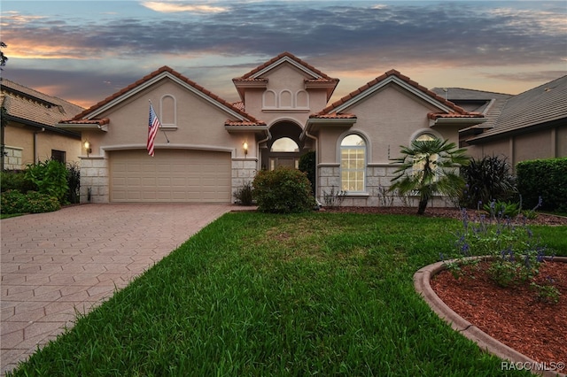 mediterranean / spanish house with a yard and a garage