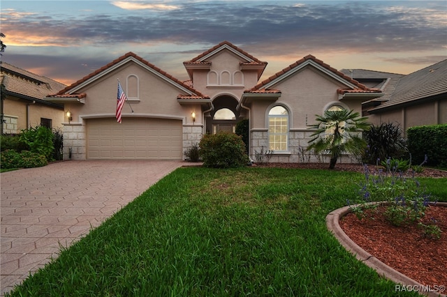 1049 W Lake Valley Ct, Hernando, FL 34442 - mediterranean / spanish-style house featuring decorative driveway, an attached garage, a yard, stucco siding, and stone siding