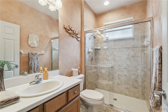 bathroom featuring tile patterned floors, vanity, toilet, and a shower with door