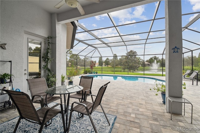 view of patio with glass enclosure and ceiling fan