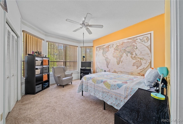 bedroom featuring ceiling fan, a closet, carpet, and a textured ceiling