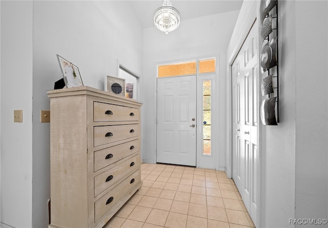 foyer featuring light tile patterned floors and a chandelier