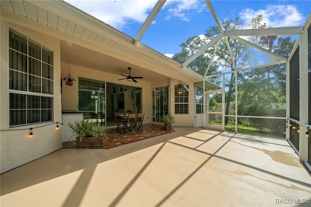 unfurnished sunroom with ceiling fan