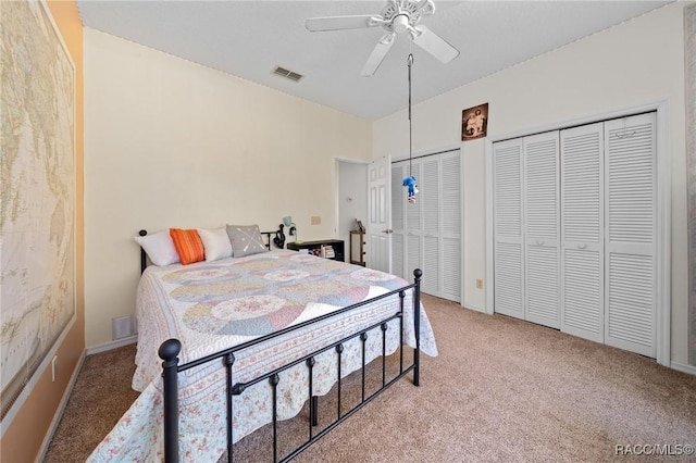 carpeted bedroom featuring ceiling fan and two closets