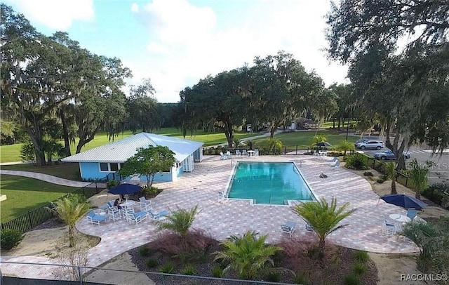 view of swimming pool with a yard and a patio