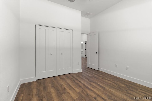 unfurnished bedroom featuring dark hardwood / wood-style flooring and a closet