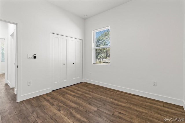 unfurnished bedroom featuring dark hardwood / wood-style flooring and a closet