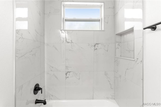 bathroom featuring tiled shower / bath