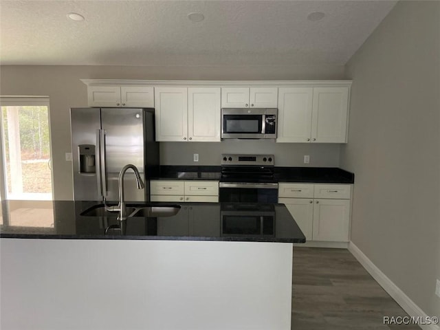 kitchen featuring sink, white cabinets, hardwood / wood-style floors, and appliances with stainless steel finishes