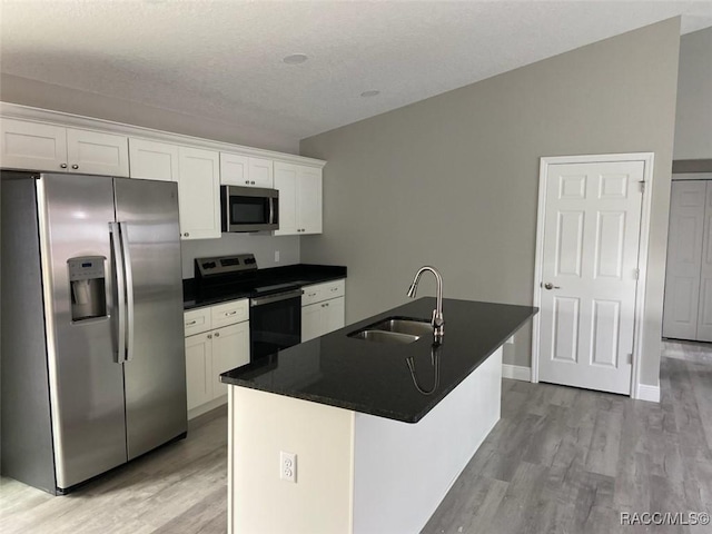 kitchen featuring white cabinetry, a kitchen island with sink, sink, and appliances with stainless steel finishes