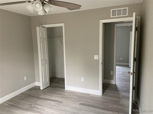 unfurnished bedroom featuring ceiling fan, a closet, and light hardwood / wood-style flooring