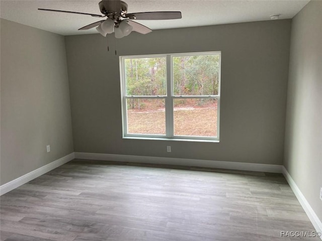 unfurnished room with ceiling fan, a textured ceiling, and light hardwood / wood-style flooring