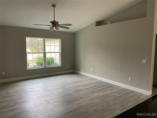 empty room featuring light wood-type flooring, ceiling fan, and lofted ceiling