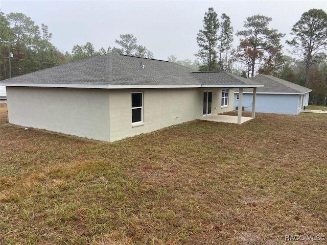 back of property featuring a lawn and a patio