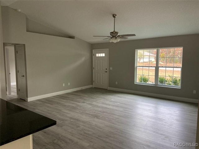 foyer featuring ceiling fan, vaulted ceiling, and light wood-type flooring