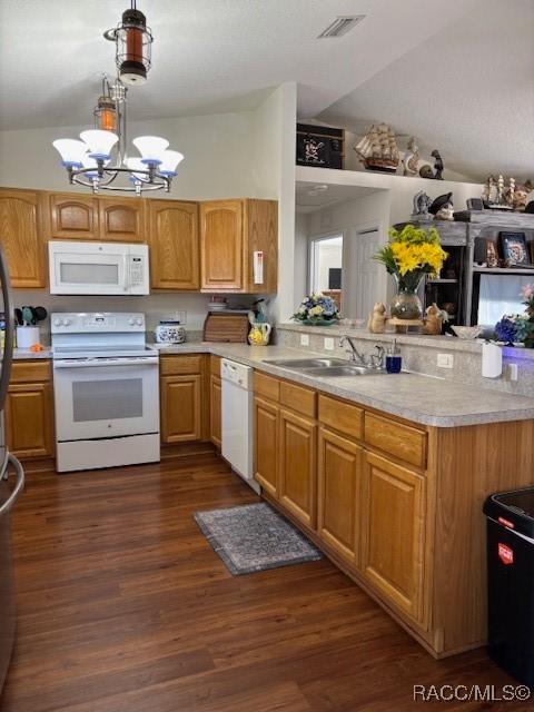 kitchen featuring dark hardwood / wood-style floors, pendant lighting, sink, kitchen peninsula, and white appliances