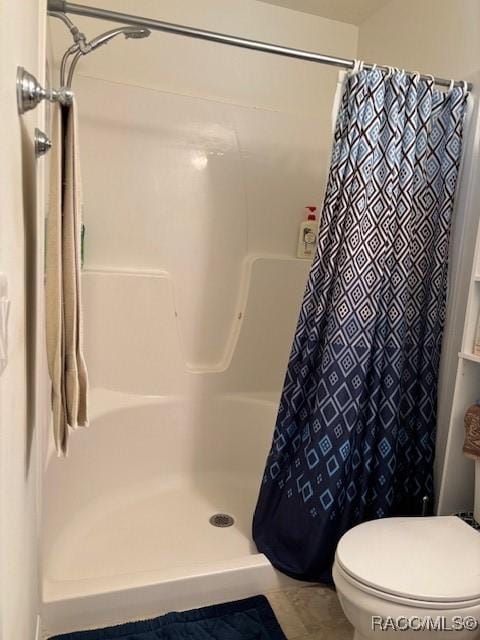 bathroom with toilet and a shower with shower curtain