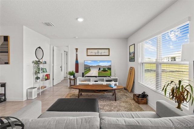457 W Fairways View Dr, Beverly Hills, FL 34465 - tiled living room with healthy amount of natural light, baseboards, and a textured ceiling