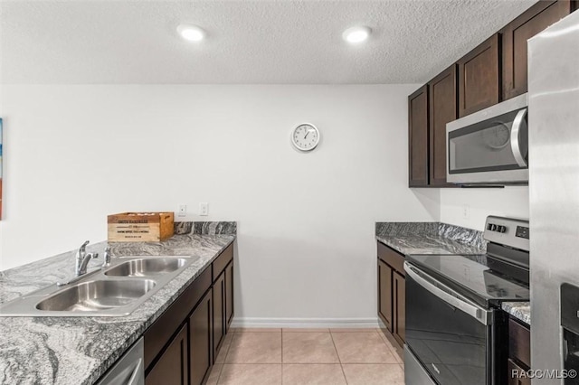 457 W Fairways View Dr, Beverly Hills, FL 34465 - kitchen with appliances with stainless steel finishes, a sink, dark brown cabinetry, light tile patterned floors, and baseboards
