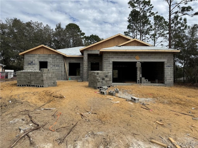 property in mid-construction with a garage and concrete block siding