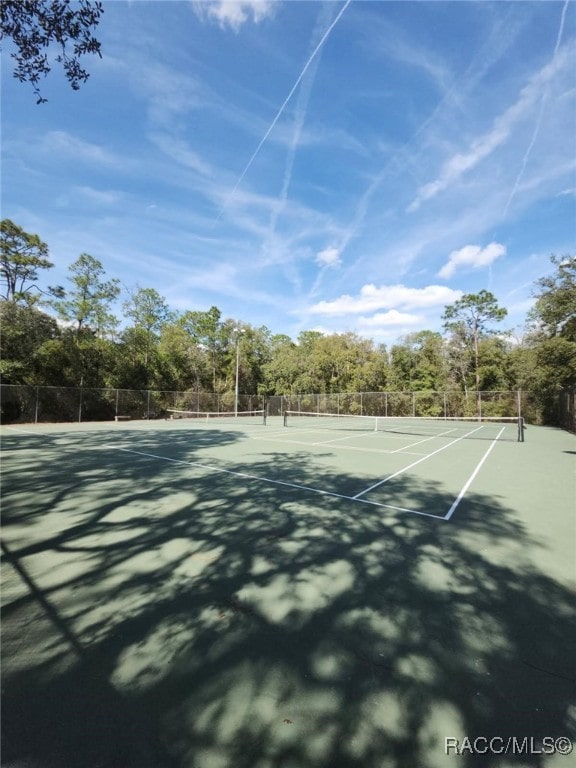 view of tennis court featuring fence