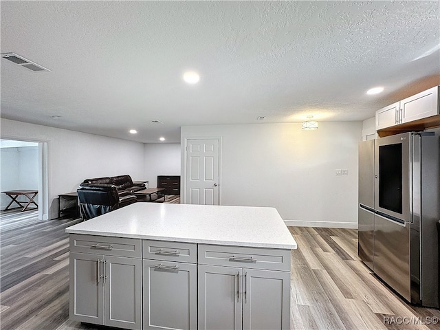 kitchen with gray cabinets, visible vents, light wood finished floors, and smart refrigerator