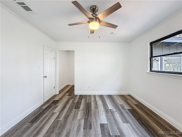 unfurnished room with dark wood-type flooring, visible vents, and baseboards