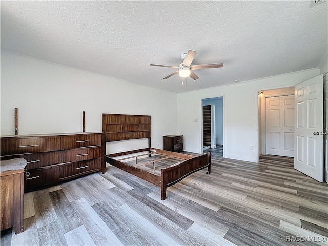 bedroom featuring a textured ceiling, ceiling fan, and wood finished floors