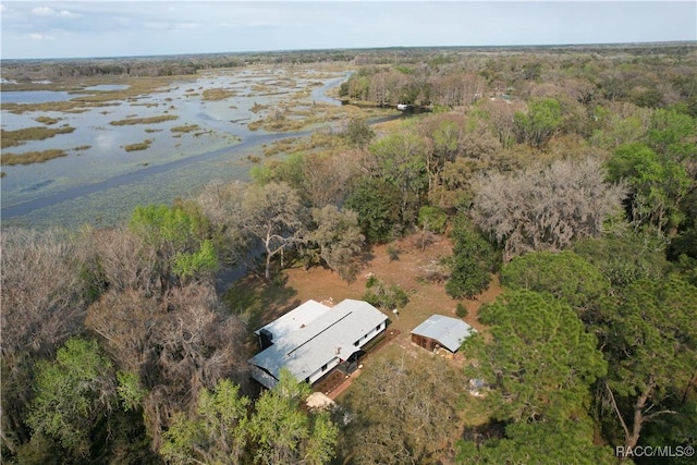 birds eye view of property with a water view and a wooded view